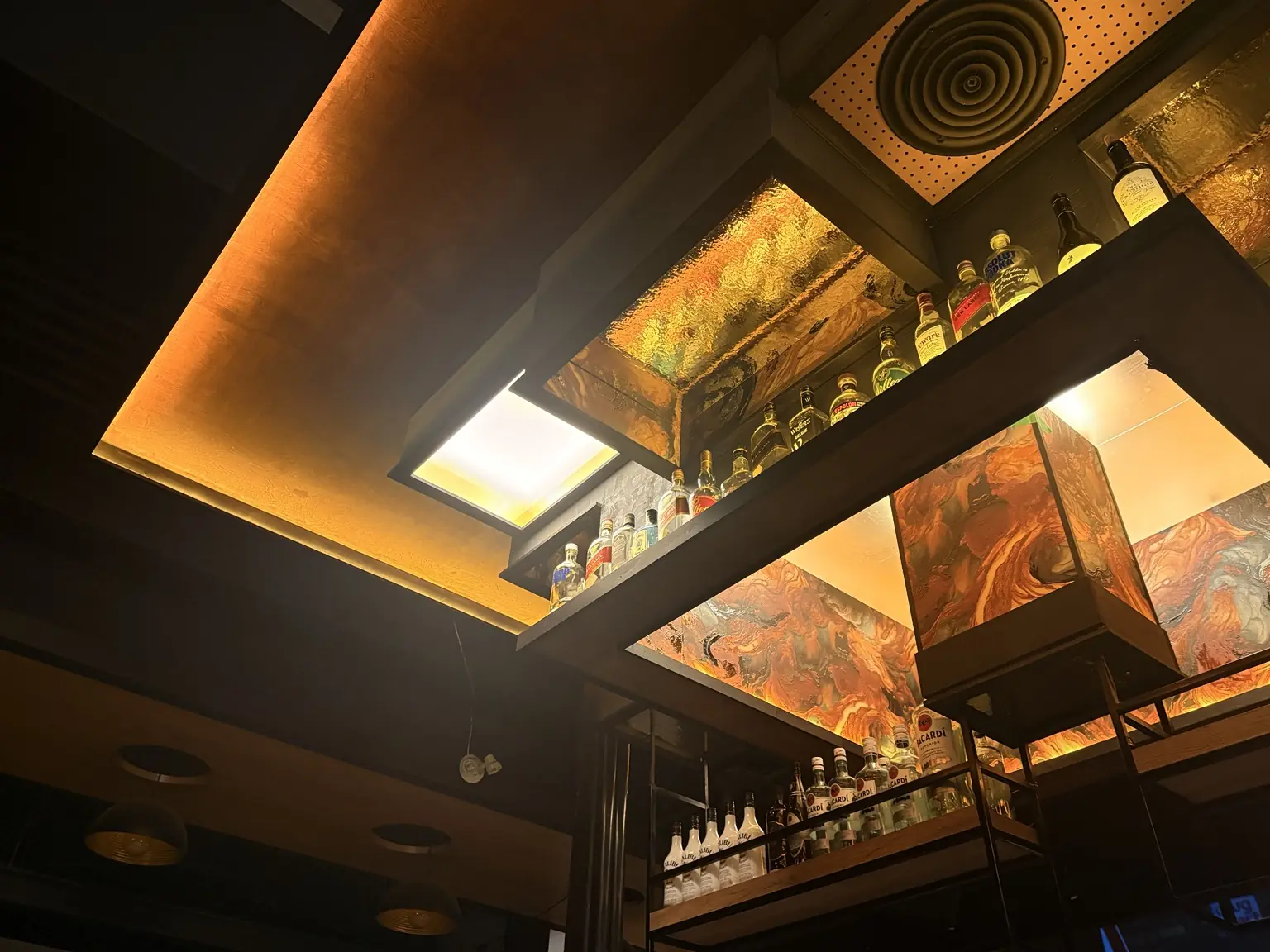 Hotferno's amber-lit bar ceiling and bottle display